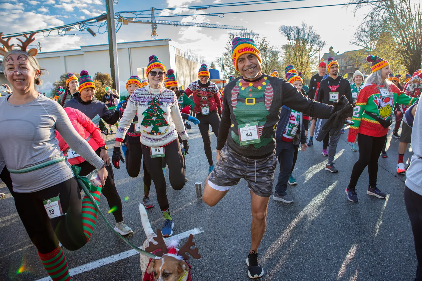Festive runners in Christmas sweaters warming up before the dash